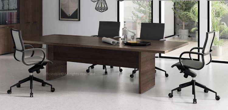 Tavolo riunioni da 240 x 120 cm con piano in truciolare spessore 38 mm rivestito in melaminico antiriflesso, gambe terminali pannellate in truciolare spessore 38 mm bordate in ABS sui lati a vista e piedini regolabili in acciaio rivestiti in polietilene con escursione di +10 mm.