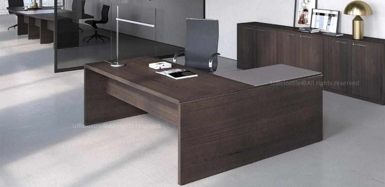 Postazione di lavoro angolare con scrivania pannellata da 160 x 190 cm, piano spessore 38 mm in truciolare nobilitato con resine melaminiche antiriflesso, modesty panel, allungo laterale con piano in vetro temprato da 10 mm incollato su supporto in truciolare da 28 mm e libreria modulare a 6 ante battenti da 270 x 46,2 x 81,3 cm con top e fianchi di finitura.