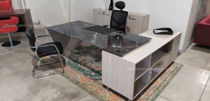 Scrivania direzionale con piano in vetro temperato retroverniciato effetto marmo, disponibile in marmo nero o bianco, mobile di servizio collegato con due ripiani a giorno e tre cassetti con serratura, ingombro complessivo 190 x 180 cm, e libreria a 4 ante composta da due contenitori a due ante con serratura, realizzata in conglomerato ligneo rivestito in melaminico classe E1.
