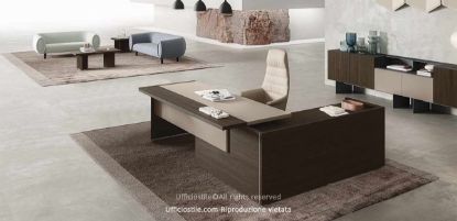 Composizione direzionale con scrivania dotata di piano scorrevole lato operatore, modesty panel in melaminico cappuccino o nocciola, mobile di servizio portante con anta scorrevole soft-closing e serratura, e madia a sei moduli con ante, moduli a giorno, basi alte 26,1 cm e carter di copertura.