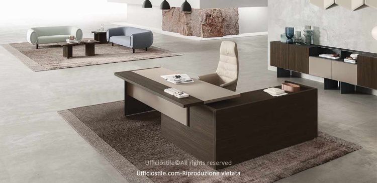 Composizione direzionale con scrivania dotata di piano scorrevole lato operatore, modesty panel in melaminico cappuccino o nocciola, mobile di servizio portante con anta scorrevole soft-closing e serratura, e madia a sei moduli con ante, moduli a giorno, basi alte 26,1 cm e carter di copertura.