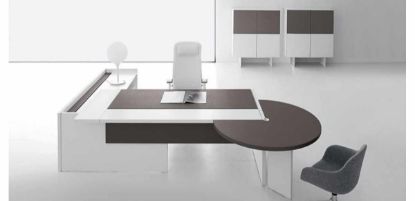 Composizione direzionale con scrivania dotata di piano scorrevole lato operatore, modesty panel in melaminico cappuccino o nocciola, piano fisso con spazzolina nera per gestione cavi, mobile di servizio portante con anta scorrevole soft-closing e serratura, e penisola con gamba per riunioni brevi o attività collaborative.