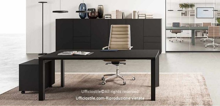 Postazione direzionale Ufficiostile con scrivania da 160 x 90 cm in MDF rivestito melaminico con bordi ABS, telaio in estruso di alluminio a sezione trapezoidale, gambe con montanti in alluminio a sezione triangolare e piedini livellatori, cassettiera metallica su ruote con vaschetta portacancelleria e 2 madie da 180 x 50 cm con cassetti push-pull su guide telescopiche.