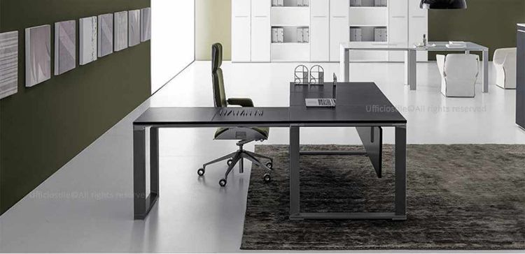 Scrivania direzionale con piano in MDF spessore 18 mm rivestito in melaminico nero opaco, bordi perimetrali in ABS da 2 mm, allungo laterale da 120 x 60 cm, modesty panel, telaio perimetrale in estruso di alluminio a sezione trapezoidale e gambe con montanti in alluminio a sezione triangolare dotate di piedini livellatori.