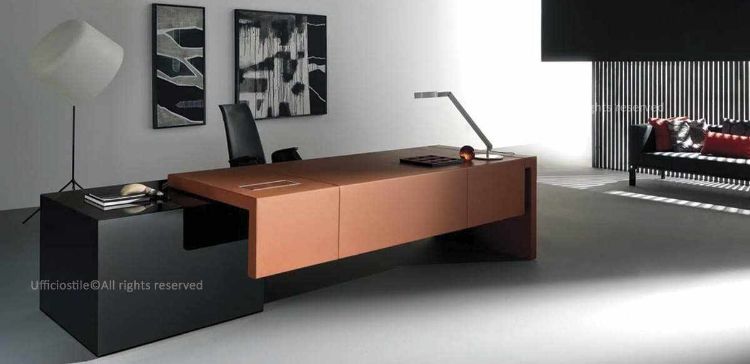 Scrivania direzionale da 220 cm con piano e gamba spessore 70 mm rivestiti in ecopelle, mobile strutturale quadrato 90 x 90 cm laccato opaco con 3 cassetti con maniglie a gola, vano porta PC o porta borse con griglia di aerazione, tappo passacavi sul top e top access integrato per elettrificazione della postazione.
