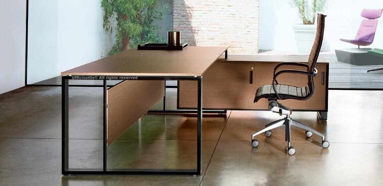 Scrivania da 180 x 100 cm con piano in melaminico appoggiato su struttura metallica con piedini di regolazione, abbinata a mobile di servizio portante sospeso da terra di 10 cm, diviso in due scomparti, con anta scorrevole con serratura, vano portaborse interno e flap integrato sul top con vasca metallica per alloggio prese.