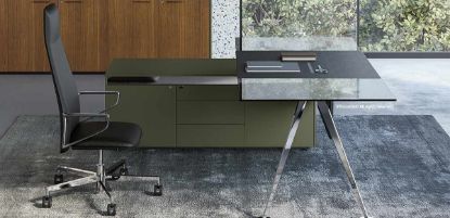 Scrivania direzionale in vetro fumé con piano temprato da 180 x 90 cm spessore 12 mm, sottomano in ecopelle nero, gambe cromate con basi circolari e mobile di servizio portante laccato opaco grigio verdastro con 3 cassetti centrali e 2 ante laterali.