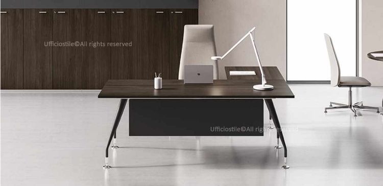 Scrivania da 180 cm con allungo laterale 100 x 65 cm, piano in conglomerato ligneo rivestito melaminico, struttura in tubolare metallico conico, gamba verniciata bianco o antracite semilucido, piedino livellatore cromato e modesty panel in MDF nero opaco per uffici operativi e direzionali.