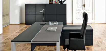 Scrivania direzionale Ono con piano di lavoro 180 x 100 cm parzialmente scorrevole e rivestito in pelle, formella centrale movibile con escursione di 10 cm per accesso al cablaggio, gamba in profilo estruso di alluminio trapezoidale, mobile portante con anta, cassetti push-pull e secretaire con serratura, più madia modulare coordinata con ante in melaminico.