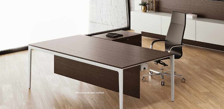 Scrivania esecutiva da 160 x 80 cm con piano in nobilitato melaminico, gamba sagomata in alluminio pressofuso verniciato con polveri epossidiche, piedino regolabile, gonna frontale, vasca di cablaggio sottopiano con fori laterali per la salita dei cavi e mobile di servizio portante su ruote con tre cassetti e anta laterale.