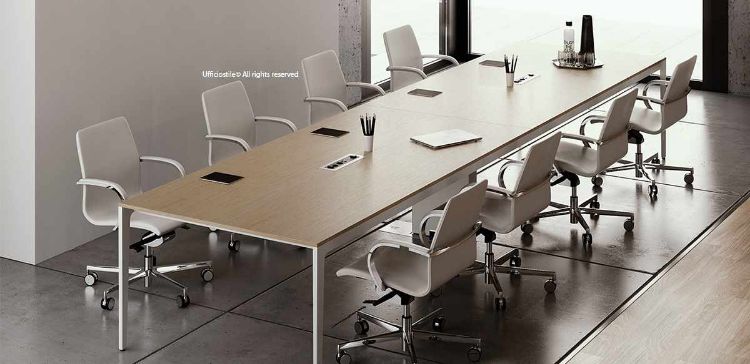 Tavolo riunioni rettangolare da 360 x 120 cm, adatto a ospitare circa 14 persone, con struttura composta da due gambe laterali e una gamba intermedia a muretto, piano elettrificato tramite scatole di cablaggio integrate e finiture disponibili, realizzato in truciolare nobilitato con resine melaminiche antiriflesso e bordato in ABS.