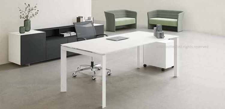 Composizione ufficio con scrivania da 160 x 80 cm in conglomerato ligneo rivestito in melaminico, gambe metalliche a U rovesciata disponibili in diverse finiture, cassettiera metallica su ruote a tre cassetti con serratura centralizzata e sistema antiribaltamento, e madia bassa da 240 x 50 cm in MDF rivestito in melaminico nero opaco con zoccolo in lamiera.