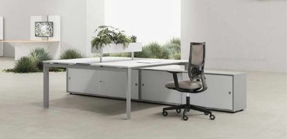 Bench a 2 postazioni composto da due scrivanie contrapposte con binario centrale attrezzabile in alluminio anodizzato, fioriera centrale, sportelli apribili per ispezione cablaggi, gambe metalliche a U rovesciata e due mobili di servizio portanti con ante scorrevoli, serratura a pulsante, piedini livellatori e finiture disponibili in melaminico colorato o neutro.