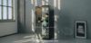 Cabina acustica singola per phone booth da 97 x 99 x 215 cm, con finitura esterna nero opaco, interno in tessuto grigio fonoassorbente, porta in vetro stratificato insonorizzante, piano di appoggio integrato, luce LED 2700 K, ventilazione silenziosa, presa 230V, porte USB type A e type C e isolamento acustico fino a 41 dB.