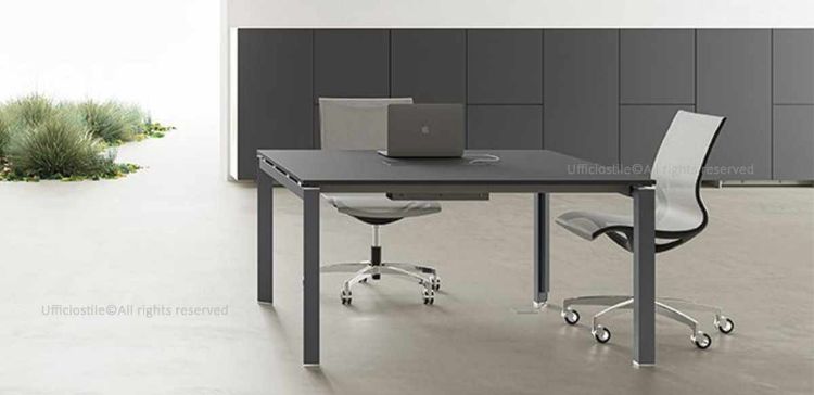 Tavolo riunioni quadrato da 140 x 136,5 cm con piano in conglomerato ligneo spessore 18 mm rivestito in melaminico nero opaco, bordi perimetrali in ABS da 2 mm, gambe a forma di U rovesciata secondo normativa EN 527-1:2011 e top access integrato per facilitare la gestione dei cavi.