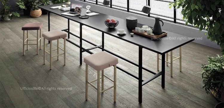 Tavolo alto per area break da 400 x 80 cm e altezza 105 cm, realizzato con piano in pannelli fibrolegnosi CARB2 spessore 30 mm nobilitati con carta melaminica, bordo ABS in tinta, struttura in tubolare rettangolare di acciaio verniciato a polveri epossidiche bianche o nere e poggiapiedi integrato per pause e sessioni di brainstorming.