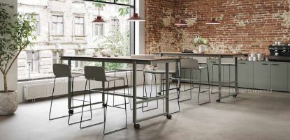 Due tavoli ufficio alti su ruote da 220 x 90 cm, altezza 105 cm, con piano in truciolare nobilitato melaminico antiriflesso, struttura in tubo d’acciaio verniciato con polveri epossidiche, quattro ruote piroettanti con freno e traverso poggiapiedi integrato alla base.