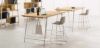 Tavolo alto h.107 da 180 x 100 cm con piano in melaminico rovere naturale spessore 25 mm, gambe in metallo verniciato bianco e gancio portaborse integrato, realizzato con pannelli in conglomerato ligneo rivestiti in melaminico e certificazioni FSC®, GREENGUARD® e CARB Phase 2.