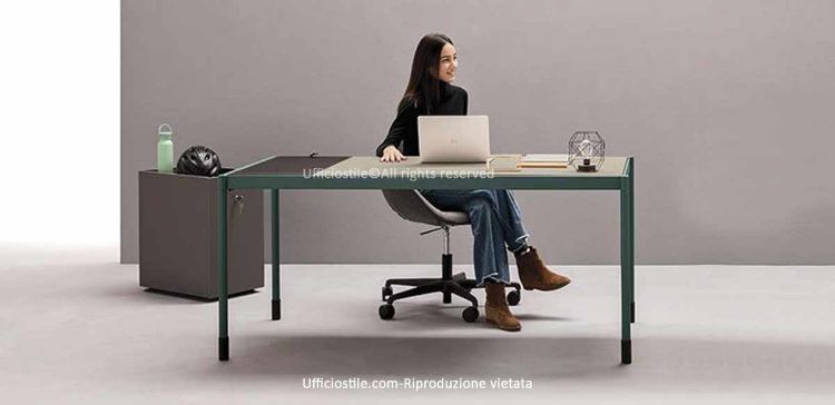 Scrivania modulare per ufficio con piano sottile in melaminico laccato opaco, telaio perimetrale in alluminio, gambe a innesto rapido e cassetto porta-oggetti integrato con chiusura soft-closing.