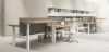 Due bench elevabili a quattro postazioni con configurazione 2+2, piani in conglomerato ligneo spessore 25 mm rivestiti in melaminico antigraffio, regolazione elettrica in altezza da 61,5 a 127,5 cm, struttura telescopica in acciaio verniciato, frontal panel in tessuto per ogni postazione e finiture disponibili in bianco, grigio chiaro, rovere chiaro, rovere tabacco, noce Maroncelli e terra d’ombra.