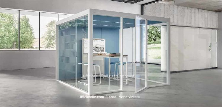 Cabina acustica multimedia room-in-room 3 x 3 metri con struttura portante in alluminio anodizzato, pareti vetrate su tre lati in vetro stratificato acustico, parete interna in tessuto fonoassorbente, soffitto chiuso con ventilazione integrata, illuminazione LED con sensore di presenza e isolamento acustico fino a 36 dB, ideale per riunioni informali, brainstorming e incontri one-to-one in open space.