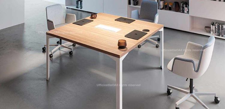 Tavolo riunioni quadrato da 140 x 140 x 75,5 cm con piano di lavoro spessore 38 mm realizzato in conglomerato ligneo rivestito in melaminico nelle finiture bianco, noce “Maroncelli” o rovere chiaro, con bordi perimetrali in ABS spessore 2 mm.