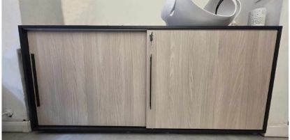 Armadio fine esposizione con scocca in melaminico finitura nero, 2 ante scorrevoli in melaminico finitura rovere, maniglia tipo B in metallo verniciato nero e dimensioni cm 125 x 42 x 114 h.