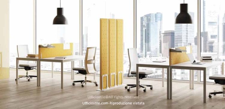 Postazioni operative modulari composte da quattro scrivanie singole da 140 x 60 cm con struttura a ponte in metallo verniciato, piani in pannelli di particelle legnose Classe E1 spessore 25 mm, due pannelli fonoassorbenti frontali e struttura freestanding con tre pannelli verticali orientabili alti 160 cm in materiale acustico riciclato rivestito in tessuto Trevira CS® ignifugo.