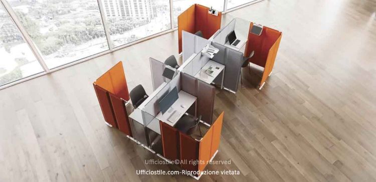 Workstation operativa per sei postazioni composta da scrivanie a ponte da 120 cm con struttura metallica verniciata a polveri epossidiche, piani melaminici spessore 18 mm bordati in ABS, pannelli divisori fonoassorbenti in tessuto ignifugo Trevira CS e pannelli trasparenti in vetro, per dimensioni complessive 360 x 240 x 120 cm.
