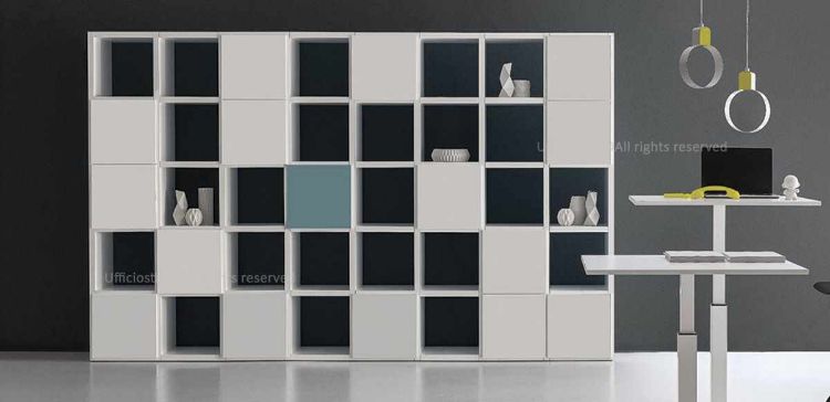 Libreria componibile per ufficio con ante e vani a giorno, struttura in conglomerato ligneo con rivestimento melaminico bianco, fianchi e ripiani da 38 mm, ante in diverse finiture melaminiche, bordi perimetrali in ABS e piedini livellatori regolabili dall’interno.