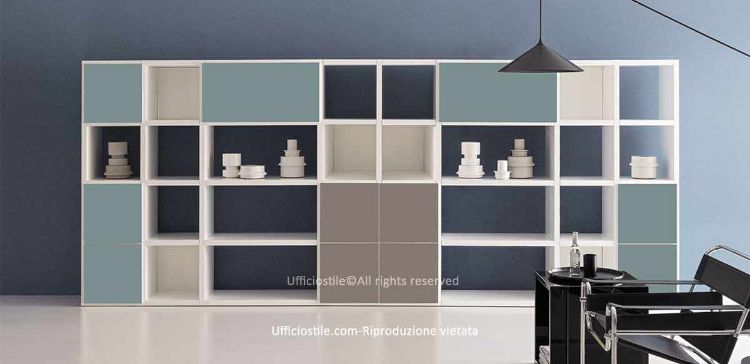 Libreria componibile per ufficio con ante push-pull e vani a giorno, struttura in conglomerato ligneo con rivestimento melaminico bianco, fianchi e ripiani da 38 mm, ante in diverse finiture melaminiche, bordi perimetrali in ABS e piedini livellatori regolabili dall’interno.