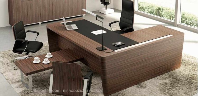 Scrivania direzionale in legno con piano in MDF impiallacciato, inserto rivestito in cuoio rigenerato, gambe in tamburato impiallacciato con vaschette e vassoi ispezionabili per raccolta cavi, allungo di servizio portante con cassettiera e tavolino caffè coordinato con piano in legno impiallacciato.