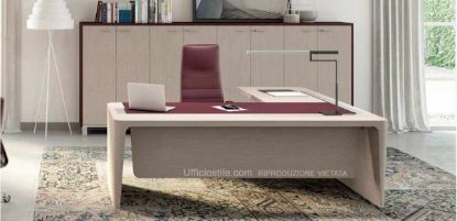 Scrivania direzionale in legno con piano in MDF impiallacciato, inserto rivestito in cuoio rigenerato, gambe in tamburato impiallacciato con vaschette e vassoi ispezionabili per raccolta cavi, allungo di servizio portante con cassettiera e libreria media a 8 ante con struttura in melaminico, ante impiallacciate in legno, top e fianchi rivestiti in cuoio e piedini metallici rettangolari.