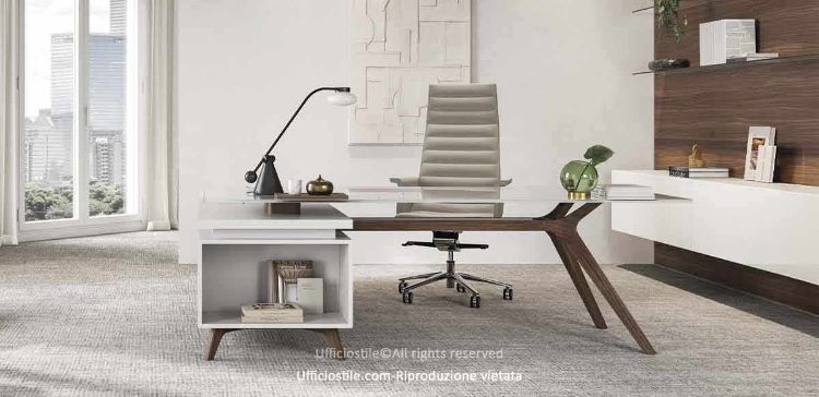 Scrivania design con piano in vetro temprato trasparente spessore 15 mm, struttura in essenza legno noce scuro e allungo di servizio portante collegato alla scrivania con due cassetti con frontali in noce scuro, apertura e chiusura sincronizzata e sistema push senza maniglie.