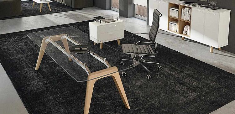 Scrivania direzionale design con piano in vetro temperato trasparente spessore 12 mm, struttura in legno massello con gambe stondate e piedini regolabili, abbinata a mobile di servizio con due cassetti con serratura e credenza contenitore con due coppie di ante e quattro vani a giorno.
