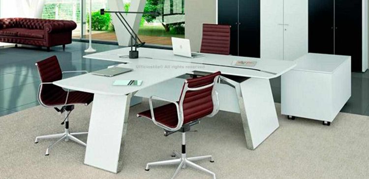 Scrivania direzionale con piano conversazione agganciato al top principale, piano in melaminico con barre decorative in metallo per il passaggio dei cavi elettrici e informatici, struttura in metallo con pannellature in legno impiallacciato, modesty panel coordinato e piedini livellatori.