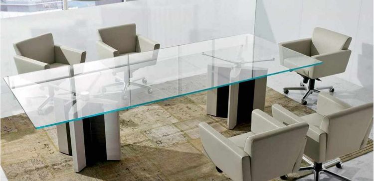 Tavolo riunioni da 300 cm con piano in cristallo extrachiaro spessore 15 mm, struttura con gambe dotate di fianchi impiallacciati e bordi rivestiti in cuoio pieno fiore, ideale per sale riunioni direzionali e ambienti ufficio di rappresentanza.