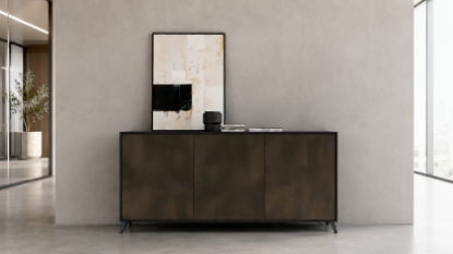 Madia contenitore di design con finitura bronzo ossidato e nero, tre ante battenti lisce con apertura push-pull senza maniglie, base rialzata su piedi perimetrali regolabili e struttura in pannelli melaminici antiriflesso a bassa emissione di formaldeide.