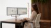 Skylon braccio monitor doppio statico per postazioni a due schermi, con fissaggio a morsetto per scrivanie da 15 a 50 mm, attacco VESA, finitura base nera, finiture opzionali bianca e argento e portata massima di 2 × 8 kg per monitor fino a 32”.