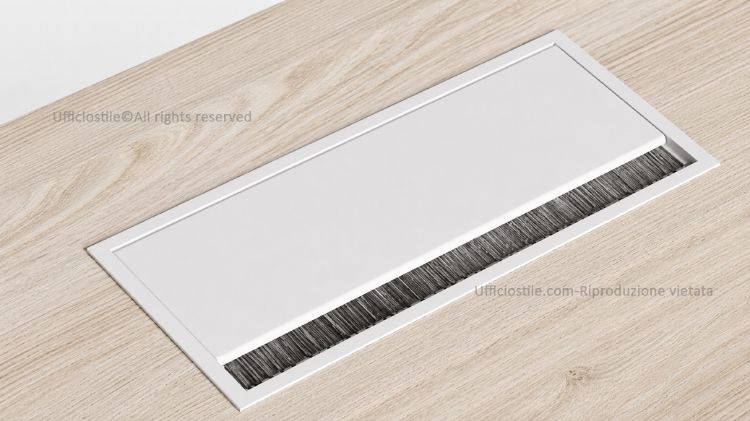 Top access in metallo da incasso per scrivania, con sportello apribile e uscita singola per il passaggio ordinato di cavi elettrici e dati attraverso il piano di lavoro, disponibile nelle finiture bianco RAL 9010, alluminio seta RAL 9006 e nero RAL 9005.