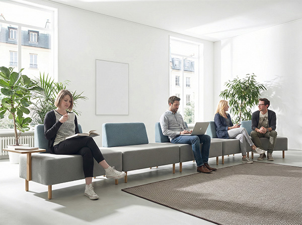 Persone sedute su panche e sgabelli ergonomici durante la pausa in ufficio